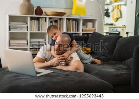 father and son using laptop computer at home