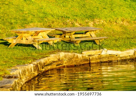 Picnic site wooden table and benches on lake shore