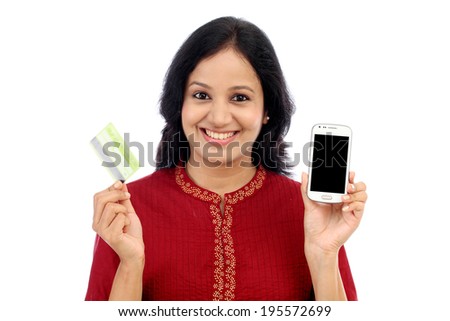 Smiling young woman holding smart phone and credit card against white