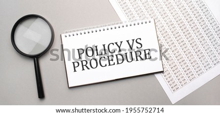 POLICY VS PROCEDURE sign in white paper notepad and magnifying glass on the grey background