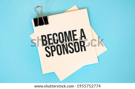 Text become a sponsor on sticky notes with copy space and paper clip isolated on red background.Finance and economics concept. Royalty-Free Stock Photo #1955752774