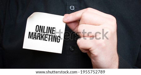 Businessman holding a card with text online marketing ,business concept