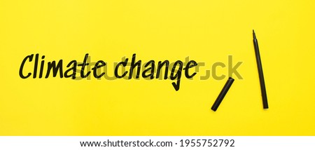 climate change word and a pen marker on yellow background. Business concept.