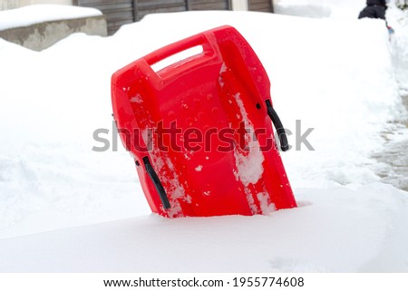 red sled stuck inside the snow