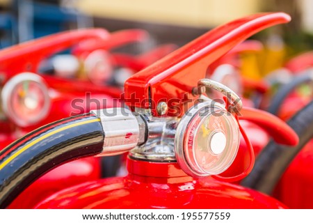 Red fire extinguishers available in fire emergencies. Royalty-Free Stock Photo #195577559