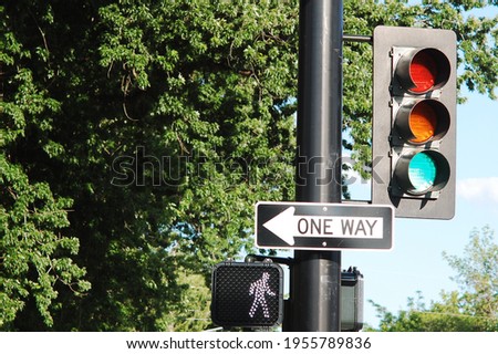 A stop light and walk symbol with a one way street sign. Traffic control signals.