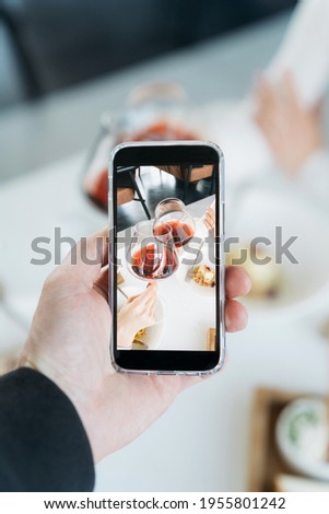 Taking food Photo of glasses with red wine on mobile phone