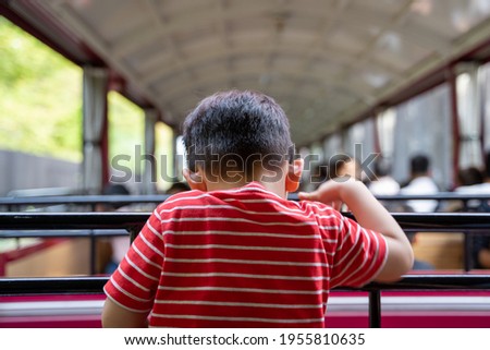 Back View of the Little boy wearing white and red shirt, Asian boy look down, Infant, child, baby, Sitting on a vintage tram