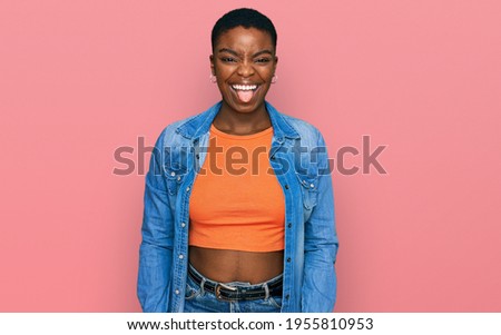 Young african american woman wearing casual clothes sticking tongue out happy with funny expression. emotion concept. 