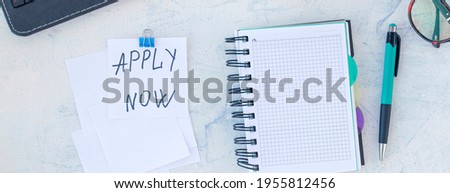 banner with Apply now. Job recruiting concept. Words Apply now in sticker on the working table with cup of coffee. Top view.