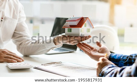 A real estate broker recommends house types and making contracts for sale and rent. Royalty-Free Stock Photo #1955817931