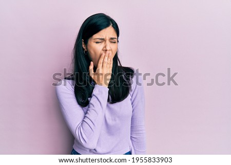 Young hispanic woman wearing casual clothes bored yawning tired covering mouth with hand. restless and sleepiness. 