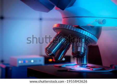 Toned photo of a backlit microscope lens in a science laboratory Royalty-Free Stock Photo #1955843626
