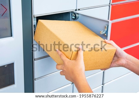 Parcel delivery, pickup point with lockers, hand with parcel, contactless pack delivery Royalty-Free Stock Photo #1955876227