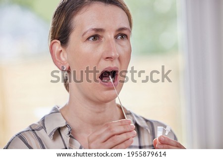 Mature Woman Taking Rapid Lateral Flow Test For Covid-19 At Home Royalty-Free Stock Photo #1955879614