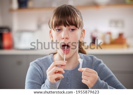 Teenage Girl Taking Rapid Lateral Flow Test For Covid-19 At Home Royalty-Free Stock Photo #1955879623