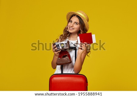 girl with red suitcase holding retro vintage photo camera