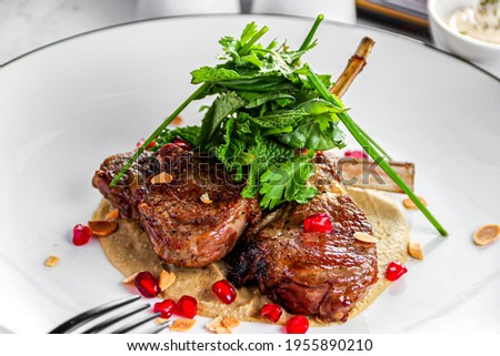 Lamb chops - confit eggplant - mint labneh sauce and pomegranate and mint on the top , on white background 