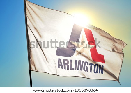 Arlington of Texas of United States flag waving on the wind in front of sun Royalty-Free Stock Photo #1955898364