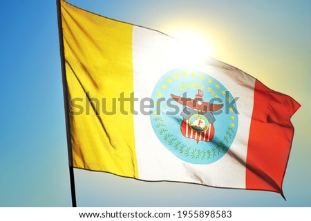 Columbus of Ohio of United States flag waving on the wind in front of sun