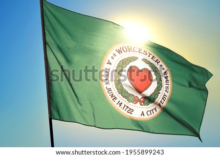 Worcester of Massachusetts of United States flag waving on the wind in front of sun