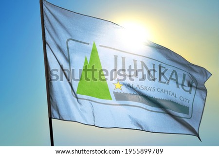 Juneau of Alaska of United States flag waving on the wind in front of sun