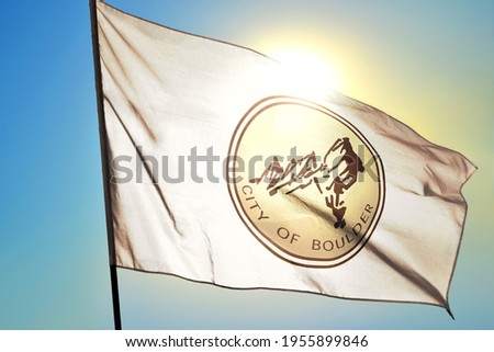 Boulder of Colorado of United States flag waving on the wind in front of sun