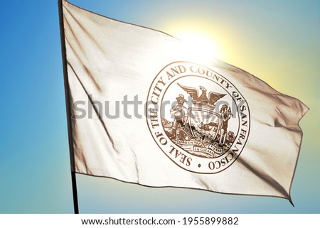 San Francisco of California of United States flag waving on the wind in front of sun