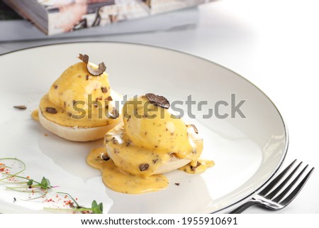 Truffle egg benedict, Poached organic eggs on english muffin - on white background
