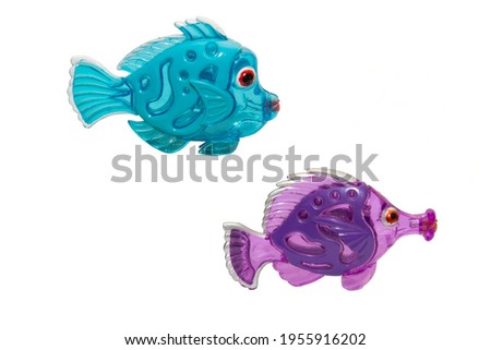 old shabby multicolored fish made of plastic on a white background