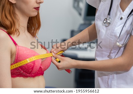 A doctor measures the chest circumference of a young patient. On the second combustible ultrasound machine. Royalty-Free Stock Photo #1955956612
