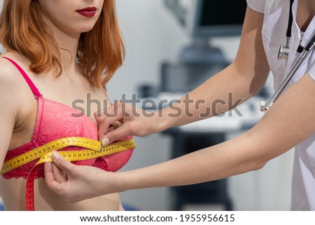 A doctor measures the chest circumference of a young patient. On the second combustible ultrasound machine. Royalty-Free Stock Photo #1955956615