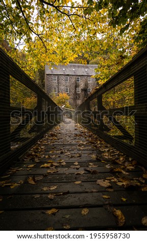 Wood Foot Bridge with Old Jute Mill in background  Royalty-Free Stock Photo #1955958730
