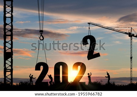 Silhouette of construction worker with crane and cloudy sky for preparation of welcome 2022 new year party and change new business. Royalty-Free Stock Photo #1955966782