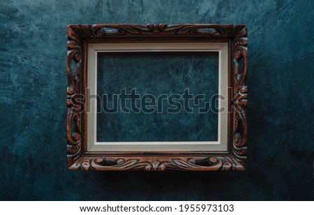 Vintage openwork wooden frame on a old wall background Royalty-Free Stock Photo #1955973103