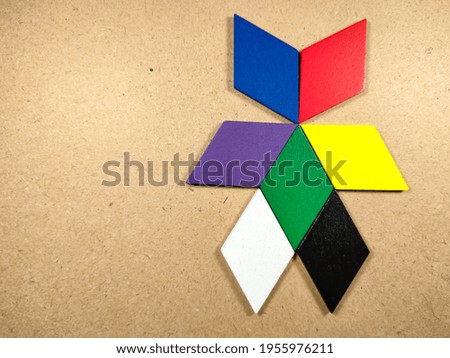 Color wood puzzle in unique robot shape on wood background with copy space.