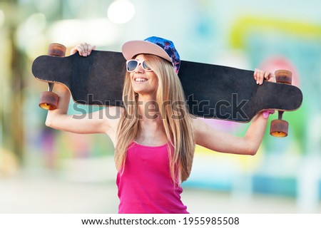 Young women surf skate or skates board outdoors on a beautiful summer day.