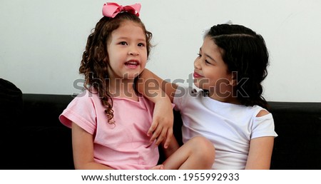 Cute hispanic little girls interaction, children speaking to each other in conversation.