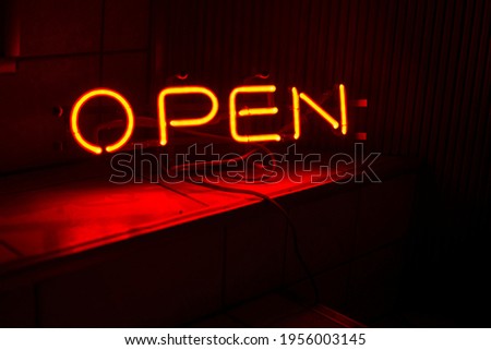 A red and orange neon OPEN sign