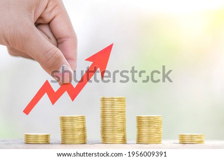 The investor's hand catches the red arrow on coins stack. Business investment ideas.