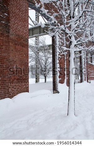 Walking near an industrial brick building under an heavy snow storm in winter 2021 in montreal, quebec, canada