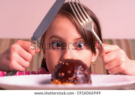 It's really delicious! Portrait of beautiful attractive young child girl with cake. Horizontal image.