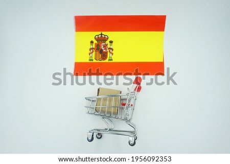 Shopping trolley and flag of spain on white background. Online shopping concept