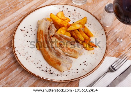 Image of fried pork bacon on a plate and French fries.