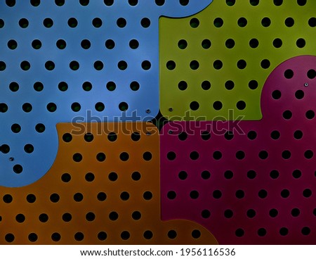 large colored mosaic with holes on the wall