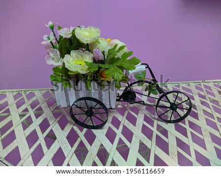 flower pot in the form of a carriage with artificial flowers inside