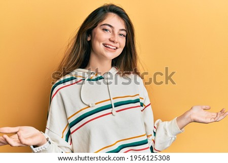 Young caucasian woman wearing casual clothes smiling showing both hands open palms, presenting and advertising comparison and balance 