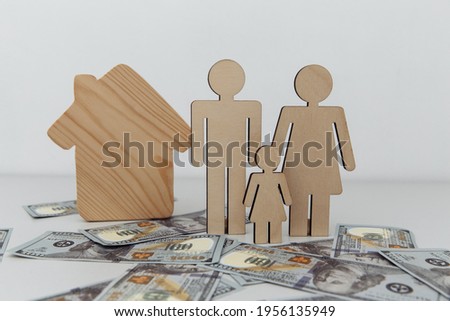 Wooden figures of family with house. Purchase or sale concept
