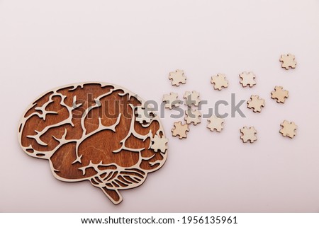 Alzheimer's disease and mental health concept. Brain and wooden puzzle on a pink background Royalty-Free Stock Photo #1956135961