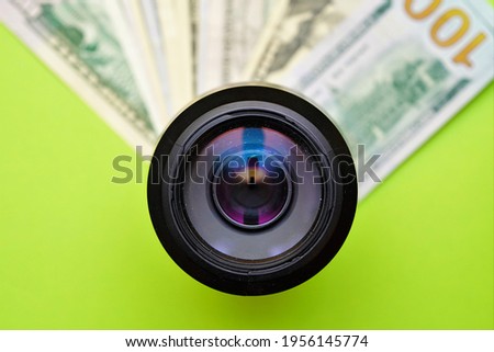 
photo camera on a background of dollars of different denominations. Earning money by taking photos. Work as a photo, earning on passion. Passive income